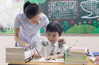 女老师在教室里给男同学辅导图片