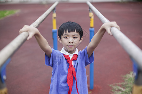 男同学在操场上锻炼双杠图片