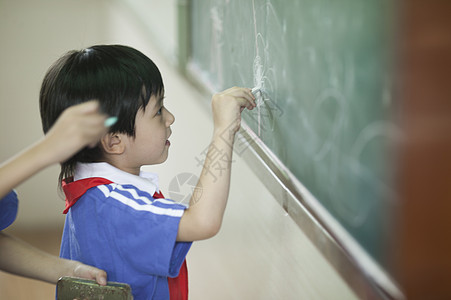 男学生在教室里写黑板背景图片