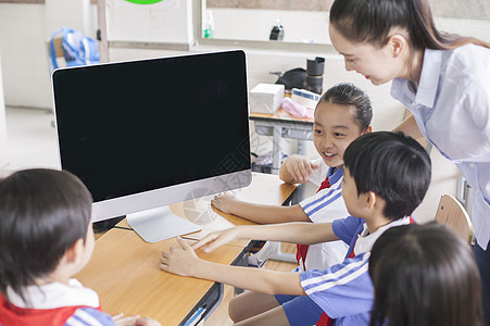 应用女老师和同学们在教室里用电脑上课背景