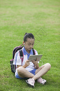 看IPAD女同学在学校草坪上用ipad学习背景