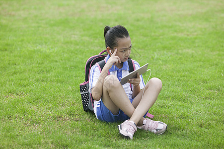 看IPAD女同学在学校草坪上用ipad学习背景