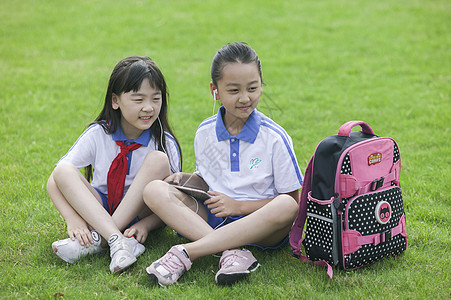 女同学在学校里草坪上用ipad 学习图片
