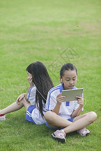 女同学在学校里草坪上用ipad 学习图片