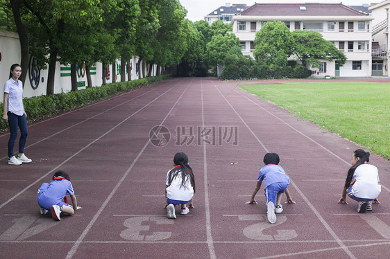 男女同学在操场跑道上比赛跑步图片