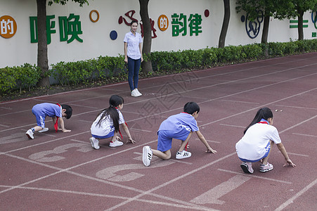 男女同学在操场跑道上比赛跑步图片