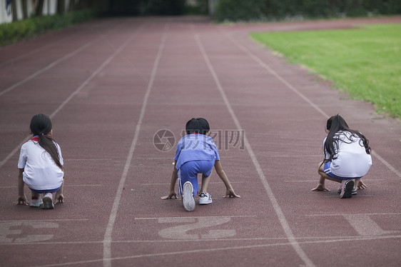 男女同学在操场跑道上比赛跑步图片