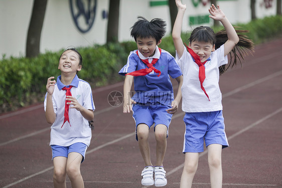 男女同学在操场跑道上比赛跑步图片