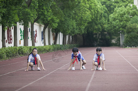 男女同学在操场跑道上比赛跑步图片