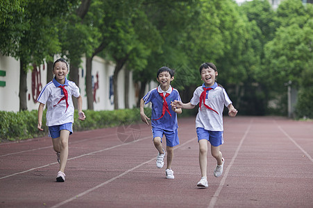 男女同学在操场跑道上比赛跑步高清图片