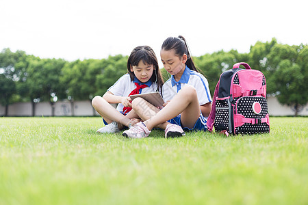 女孩在草坪读书同学在校园操场草坪在线学习知识背景