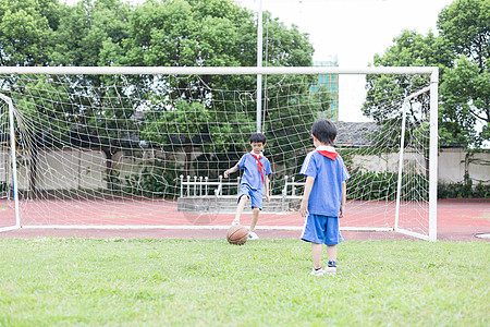 在球场上踢球玩耍的小学生高清图片