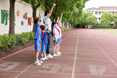 小学老师带着同学们在操场上玩耍欢呼高清图片