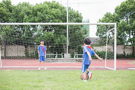 学生放学在球场上踢球玩耍的小学生背景