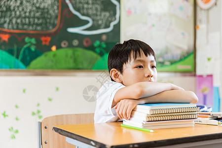 手拿书籍男孩教室课间休息男孩趴在书上背景