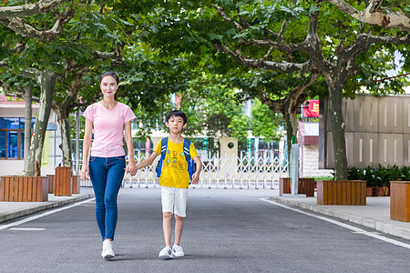 母子牵手步行校园亲子妈妈牵着儿子上学背景