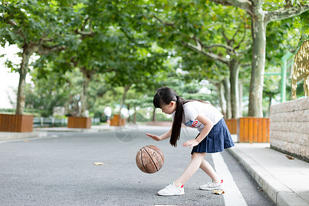 校园林荫道上打篮球的小学生女生图片