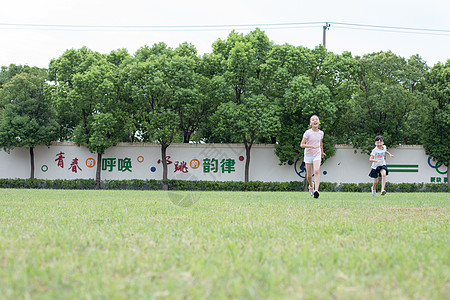 在操场草坪一起玩耍奔跑的小学生高清图片