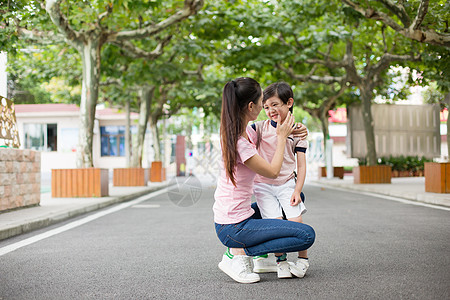 跑向校门放学后的孩子跑向妈妈的怀抱背景