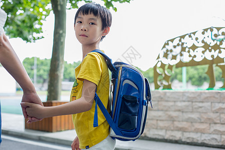 背着手的学生牵着妈妈的手去上课的小学生背景