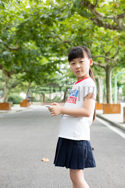 站在校园里玩手机的小学生女生图片