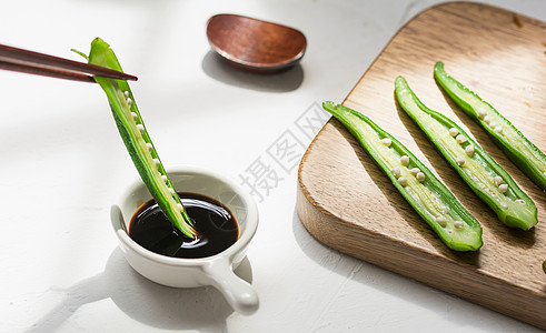 木板蔬菜新鲜秋葵沾酱油背景