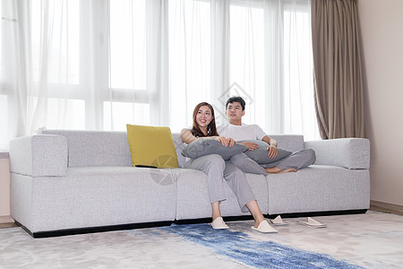 家庭场景情侣在客厅沙发放松休闲看电视背景