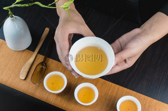 手端着白色茶碗品茶图片