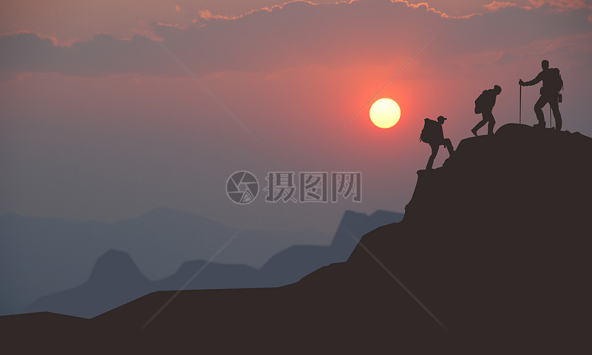 夕阳下爬山爱好者成功爬上山的顶峰图片