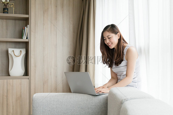 年轻女性在客厅使用家庭办公图片