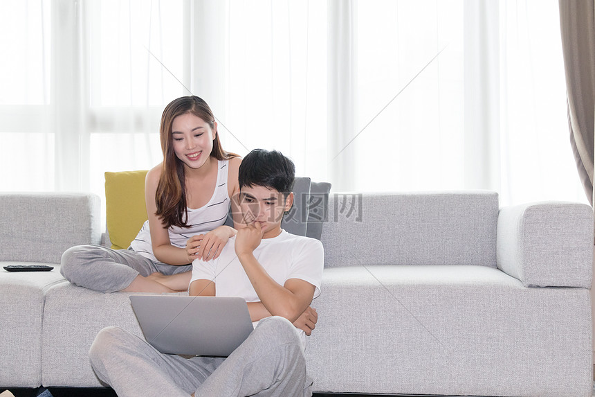 年轻夫妻一起在客厅沙发上看电视图片