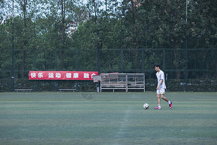 运动员在足球场训练踢球图片