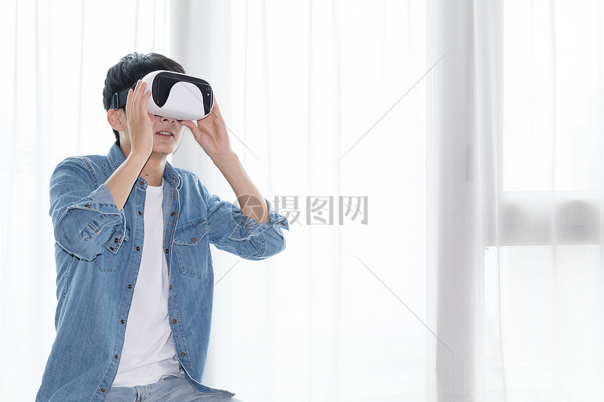 在客厅头戴vr眼镜体验虚拟现实的男士男人图片