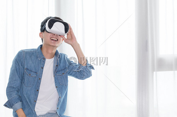在客厅头戴vr眼镜体验虚拟现实的男士男人图片