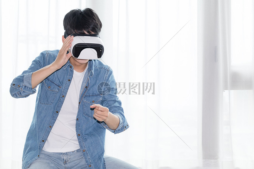 在客厅头戴vr眼镜体验虚拟现实的男士男人图片