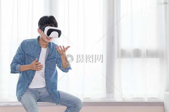 在客厅头戴vr眼镜体验虚拟现实的男士男人图片