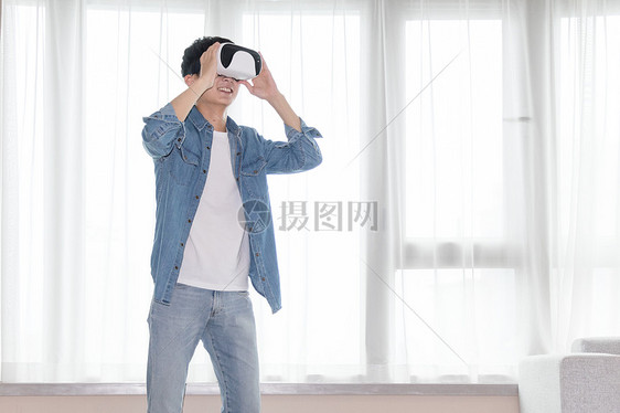 在客厅头戴vr眼镜体验虚拟现实的男士男人图片