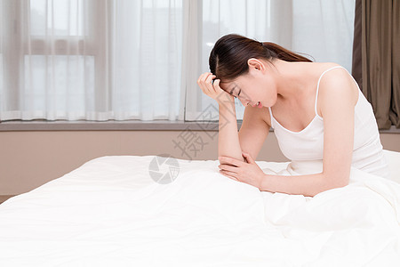 年轻女性失眠头痛坐在床上图片