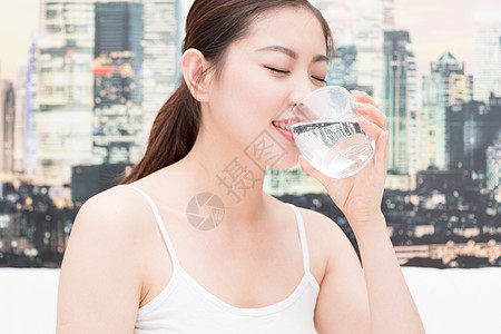 喝热水的女人早起睡前坐在床上喝水的美女背景