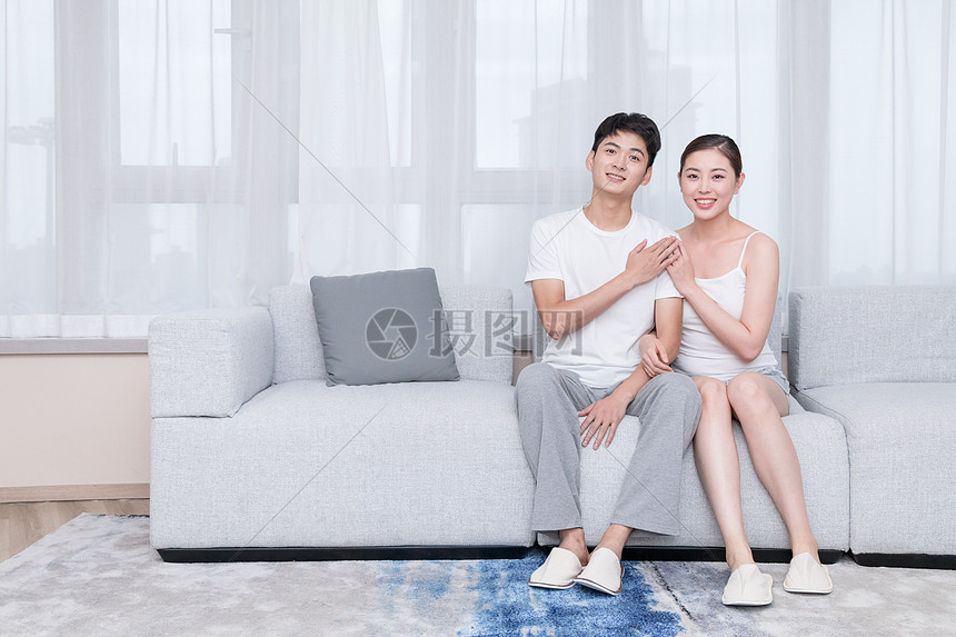 年轻夫妻坐在客厅沙发上图片