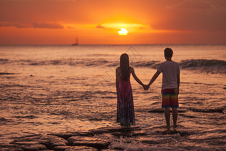 婚紗旅行中浪漫情侣在海中看夕阳背景