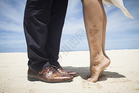 蜜月旅拍旅行蜜月中情侣在沙滩踮起脚尖亲吻背景