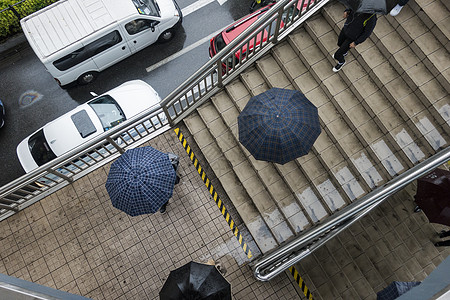 城市里雨天人们打着伞背景图片