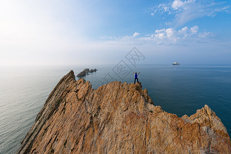 站在山峰上的人站在海边礁石上的人物背影背景