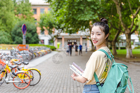 传统文化大学校园内女生抱着书本背景