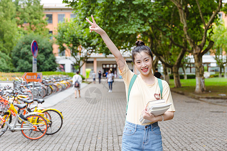 年轻女大学校园内女生抱着书本背景