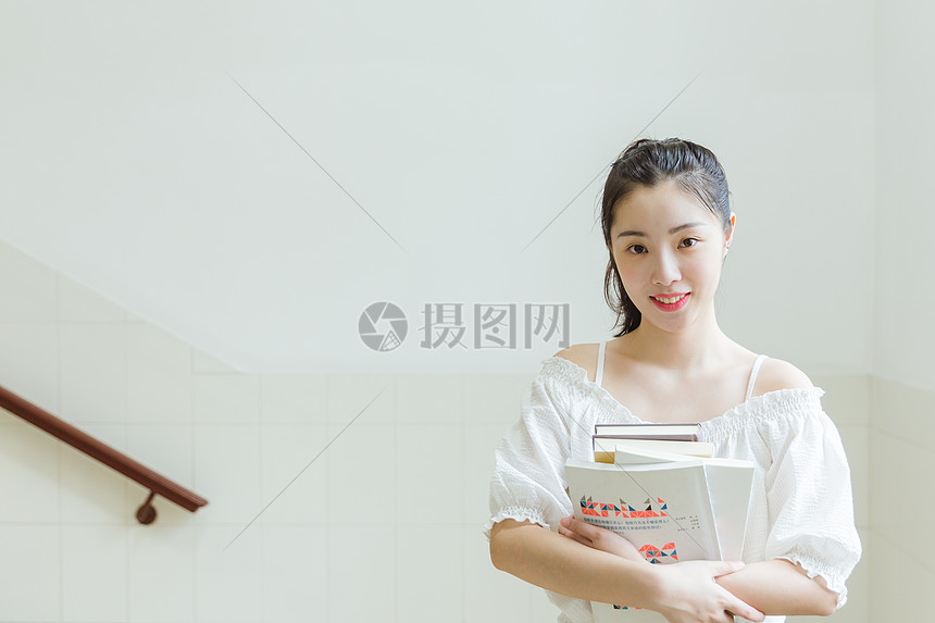 大学教学楼内女生抱着书本图片