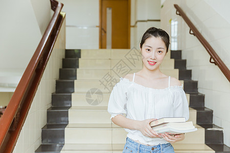 大学教学楼内女生抱着书本图片