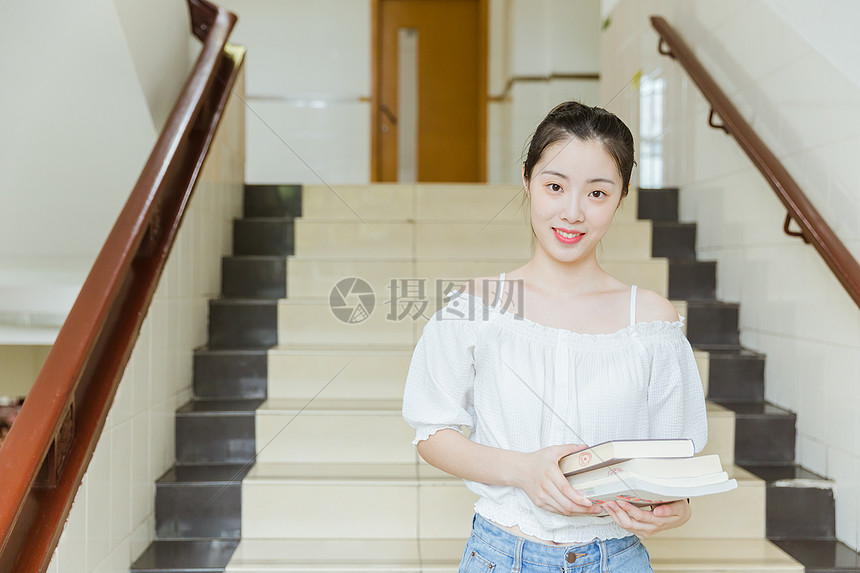大学教学楼内女生抱着书本图片