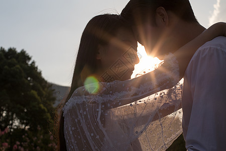 夕阳情人节情侣夕阳下拥抱头碰头剪影背景